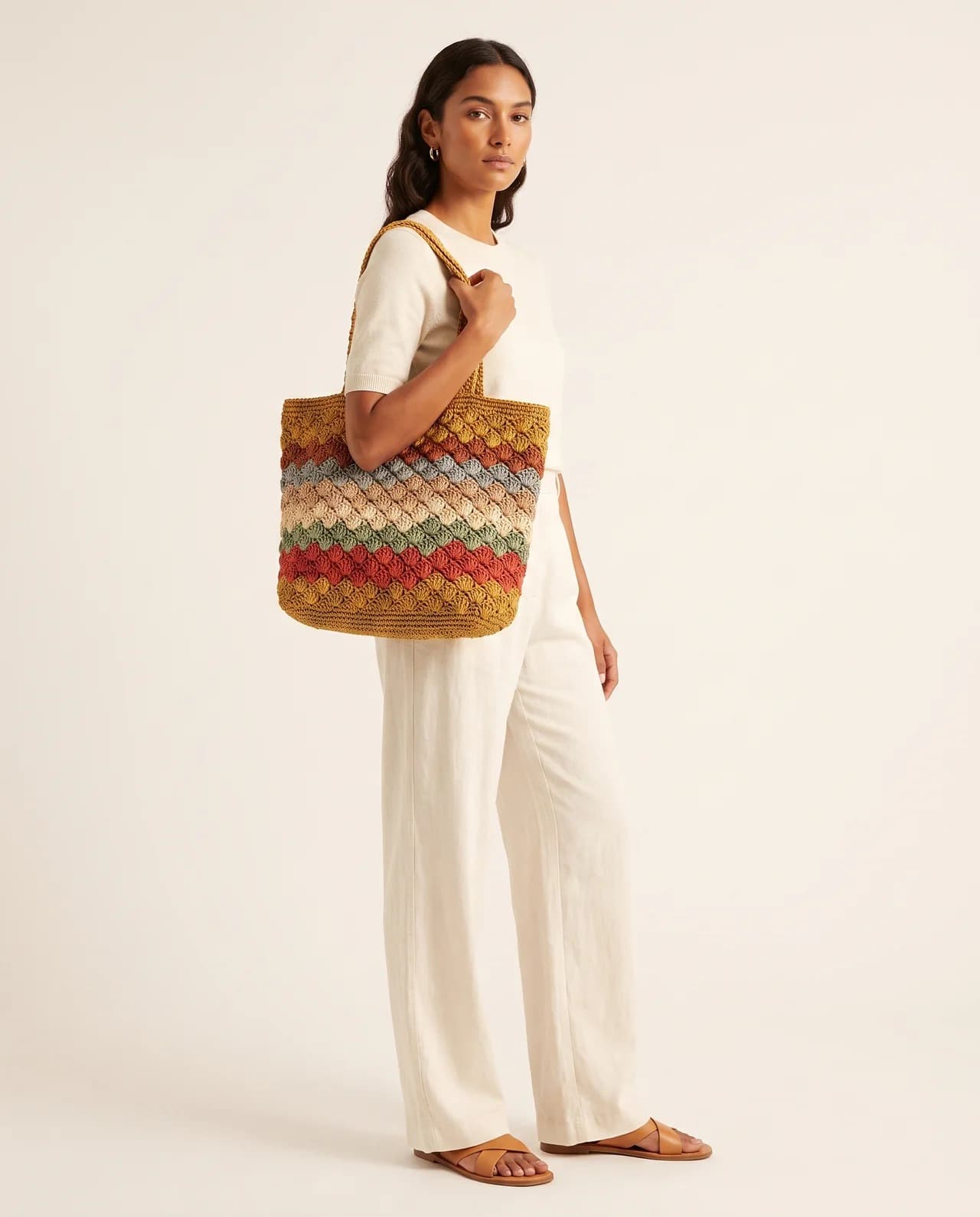 Model carrying the Fiora Basket, a large striped basket tote worked in colour