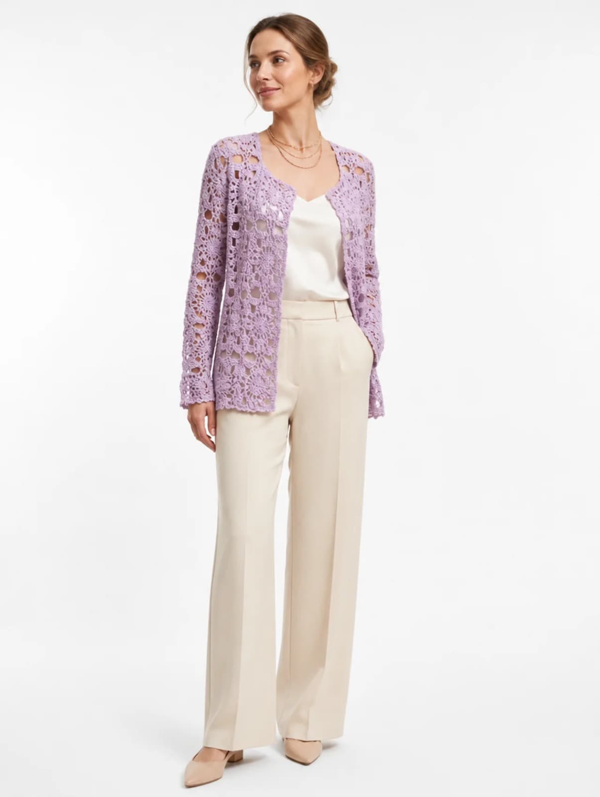 Model in an open lilac hand-crocheted cardigan over cream trousers