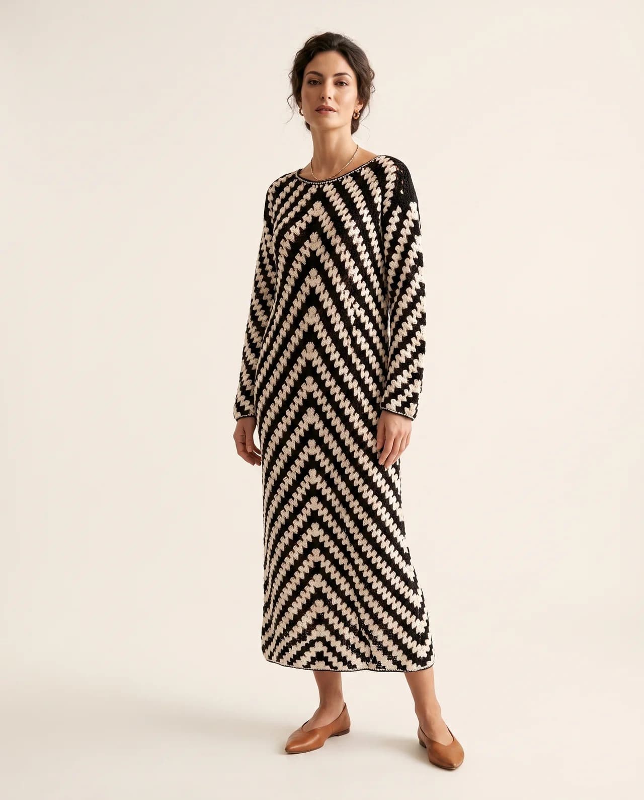 Model in the Sera Dress, a full-length hand-crocheted maxi in a black and cream chevron