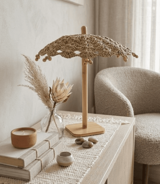 A lace crochet parasol on a wooden stand in a styled interior